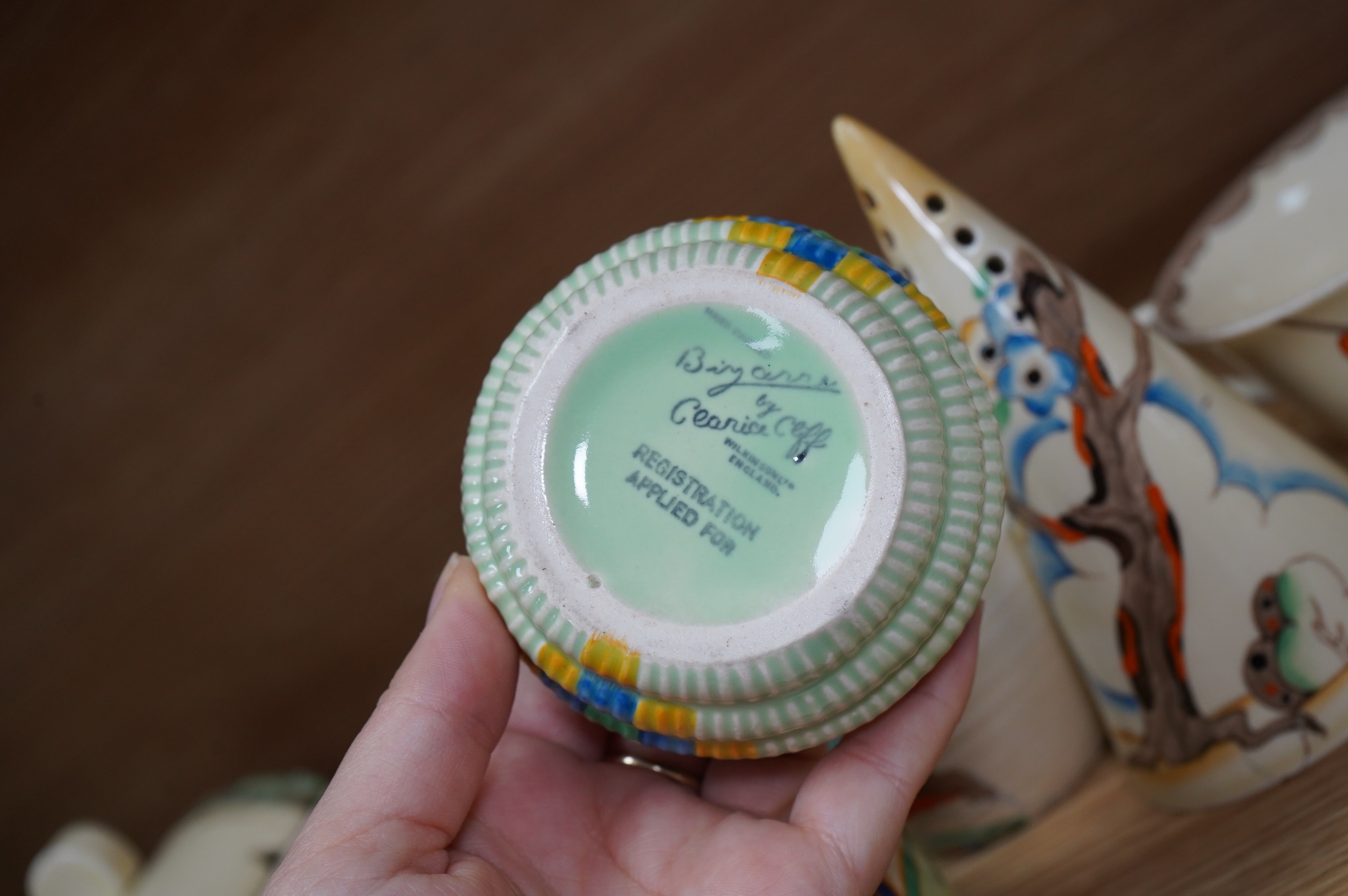 A collection of Clarice Cliff including; a Tiger Tree conical sugar sifter (c.1937), a cup marked 5799, a two handled pomegranate cup, a bowl, two plates, a mustard pot, etc. Condition - fair